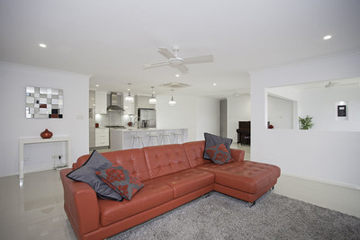 A brownish red l-shaped couch in a white living room.